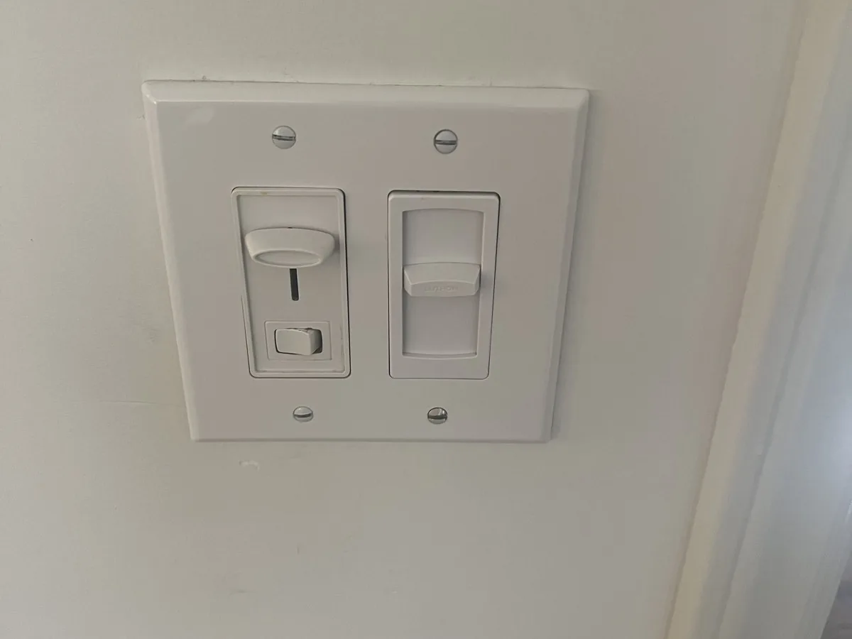 Dimmer and light switch side by side on a two-gang wall plate