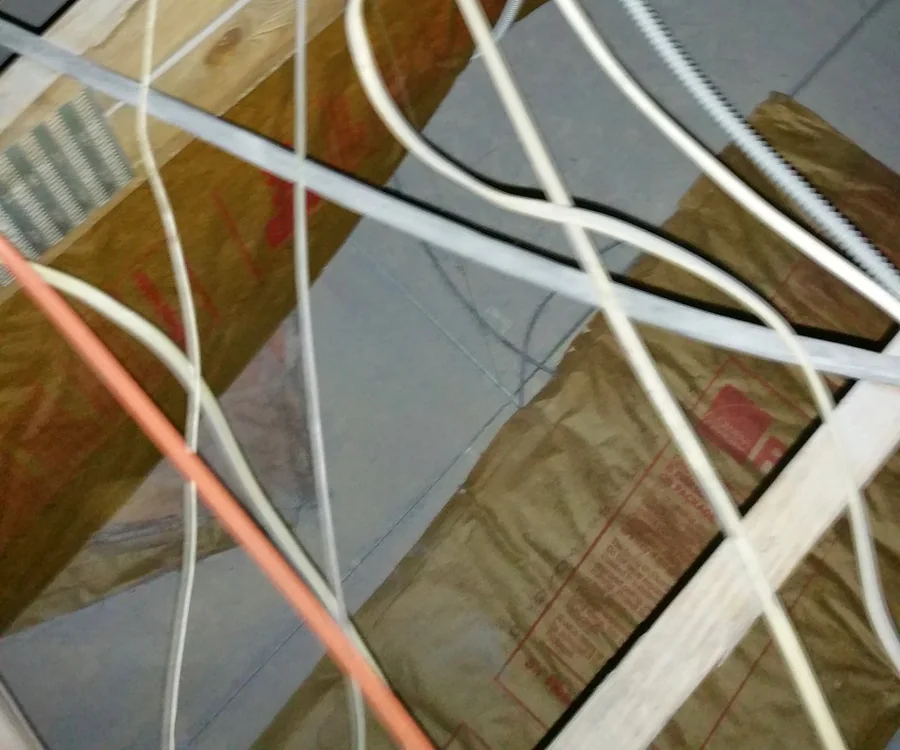 Exposed electrical wiring and a junction box among wooden attic beams and insulation in Hayes Barton, Raleigh