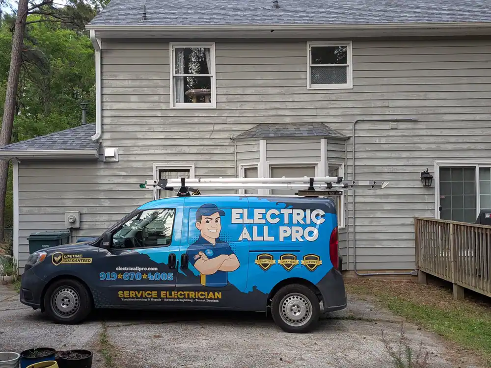 An electrician's service van parked in front of a residential house in Oakwood, Raleigh