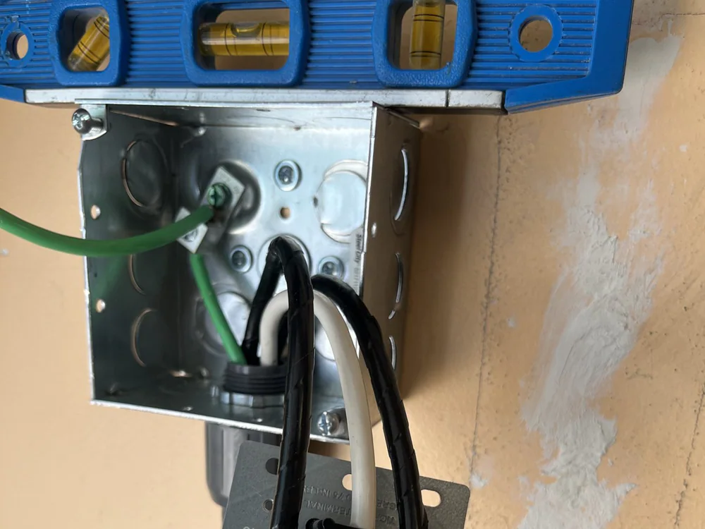 An open electrical box with exposed wires and hand tools nearby during installation work in Wakefield, Raleigh