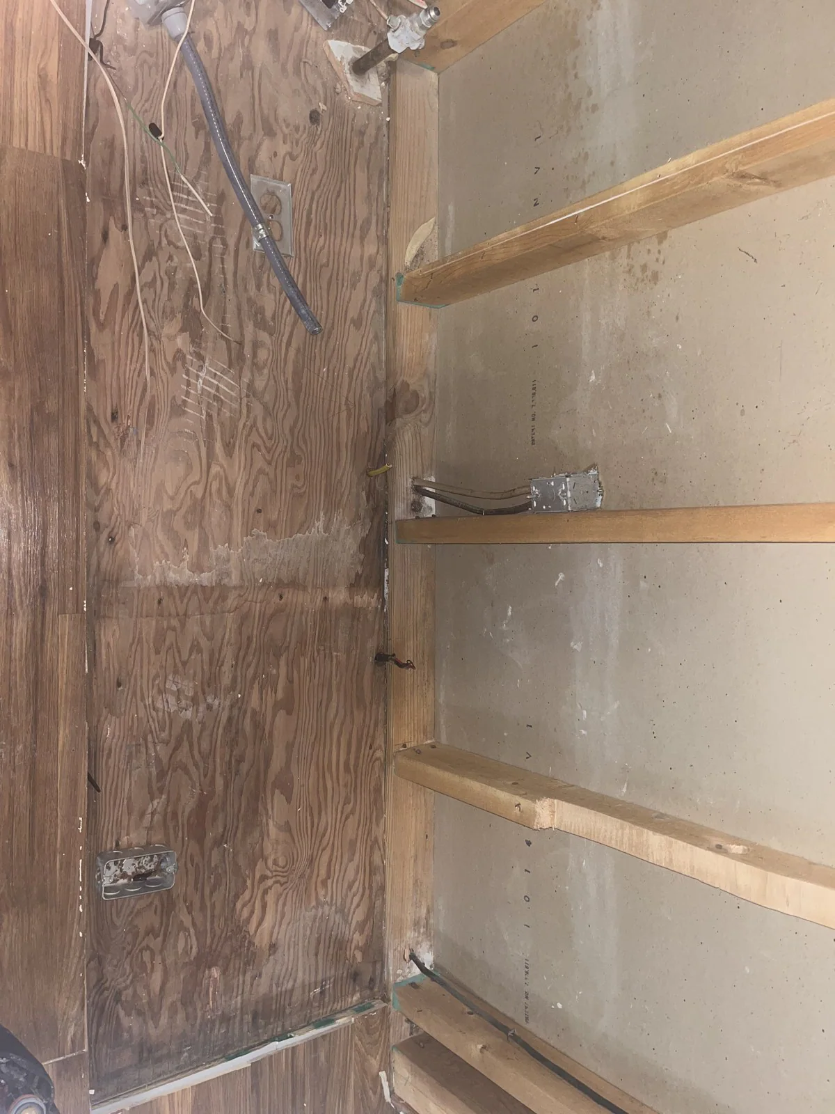 Unfinished room with exposed wooden framing, partial drywall, electrical wiring and outlet boxes mounted to the studs in Mordecai, Raleigh