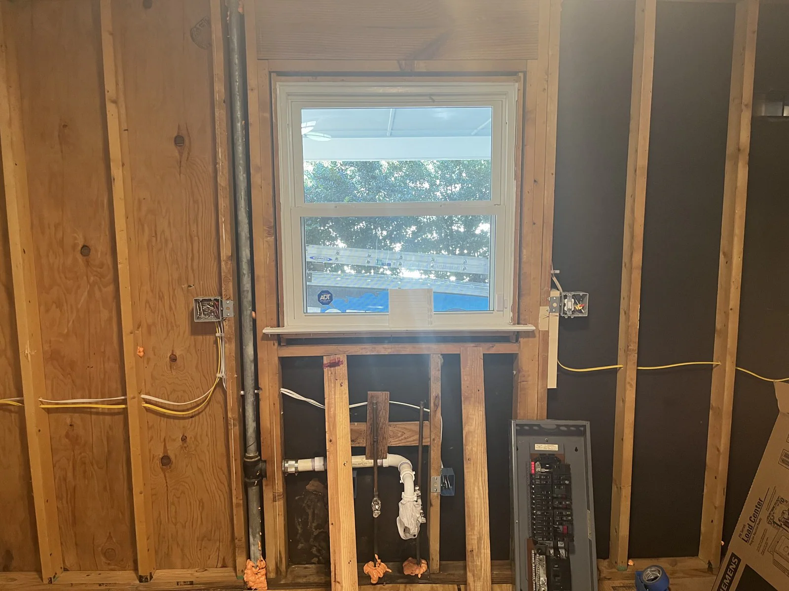 Electrical panel and surrounding wiring exposed in a wall opened during renovation in Mordecai, Raleigh