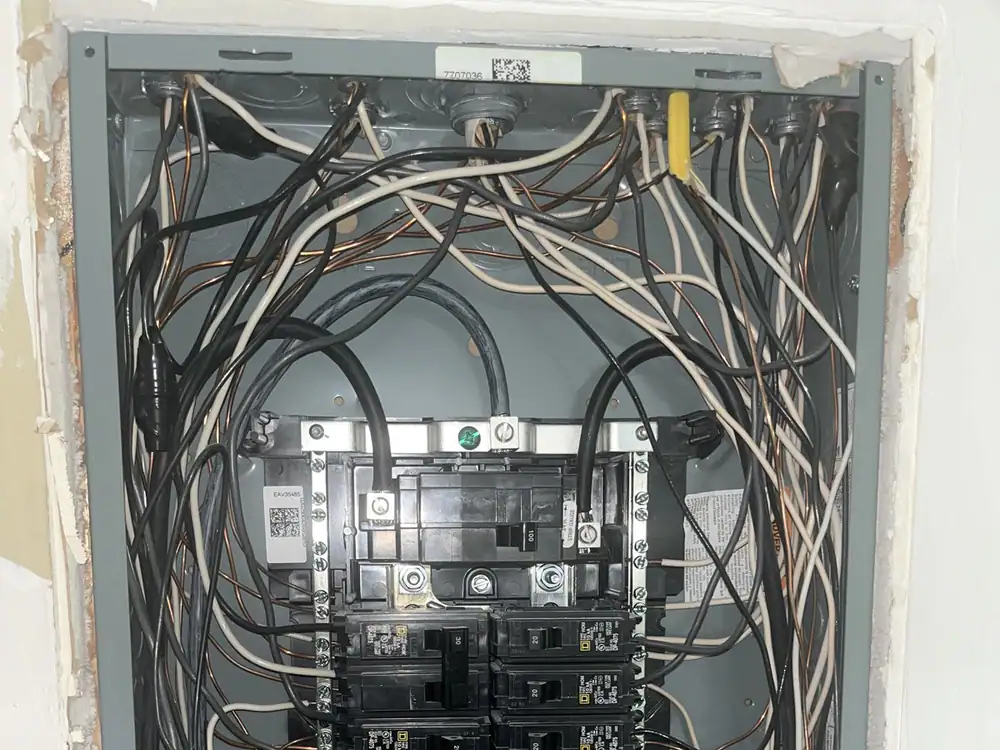 Exposed electrical panel with messy wiring and broken tie in Wakefield, Raleigh