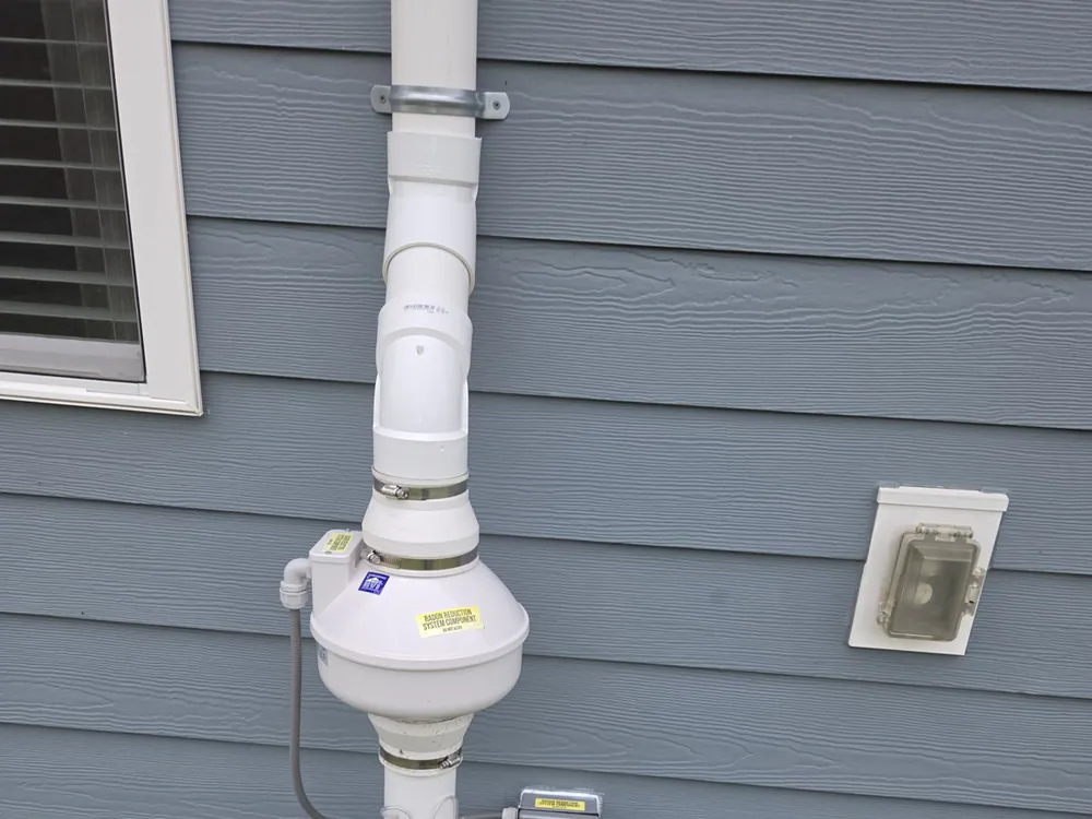 Pipe and an electrical box mounted on the exterior siding of a house in Five Points, Raleigh