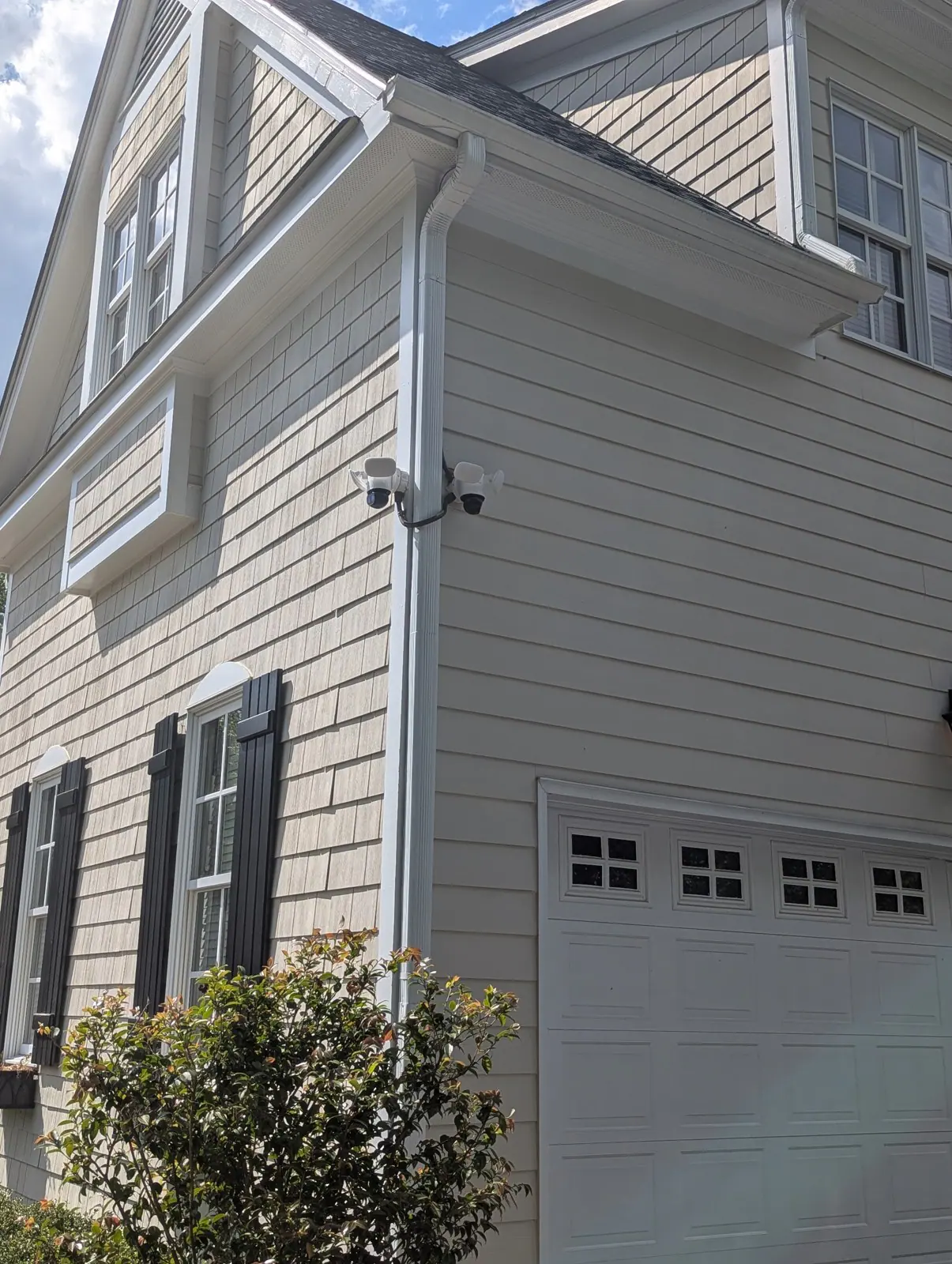 Security cameras mounted on the side of a house near a downspout, in Budleigh, Raleigh