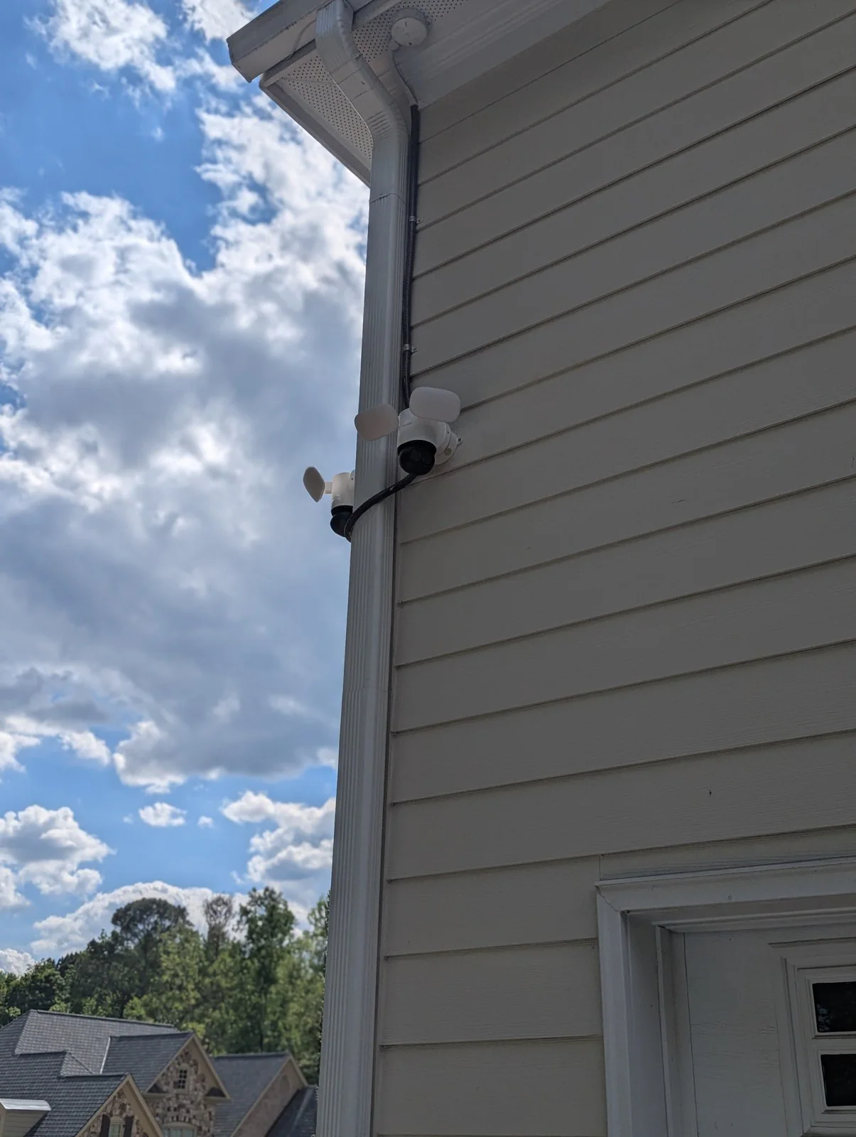 A security camera and a small device mounted on house siding near the gutter, in Budleigh, Raleigh