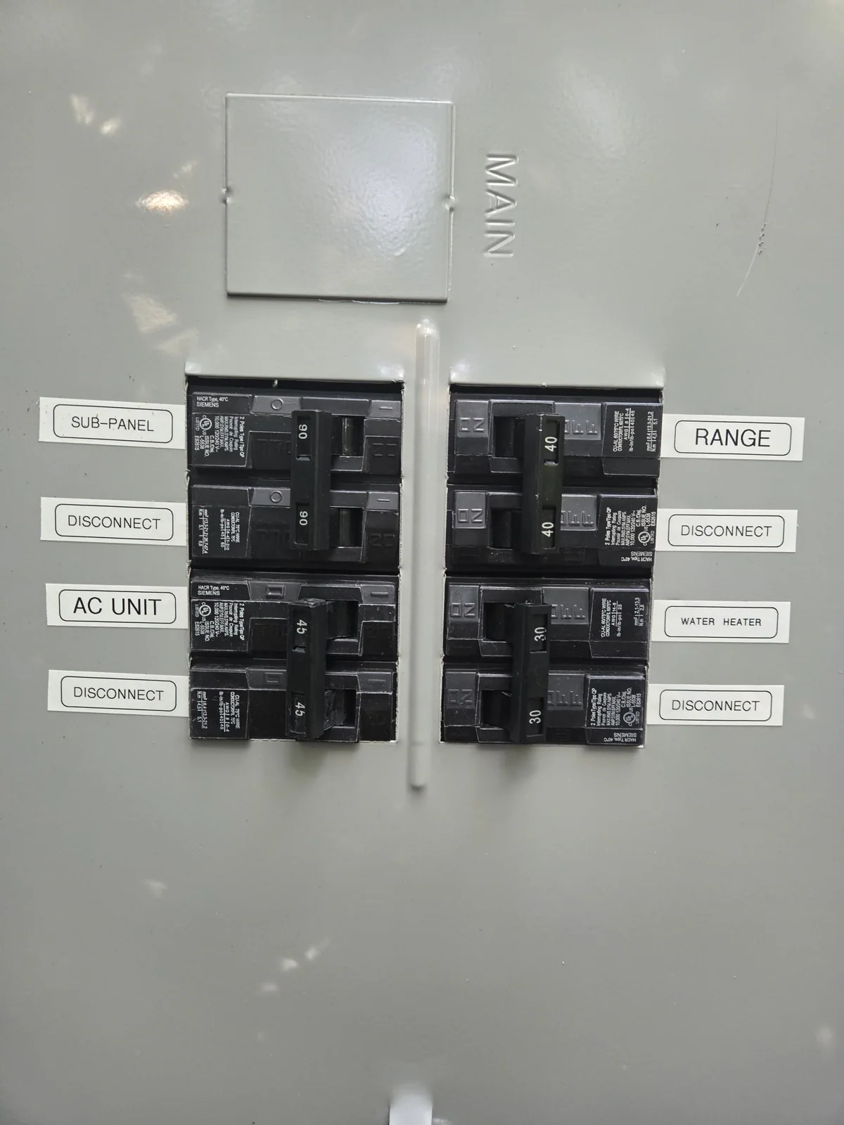 An electrical panel with breakers labeled for a sub-panel, air conditioning, range and water heater, in Oakwood, Raleigh