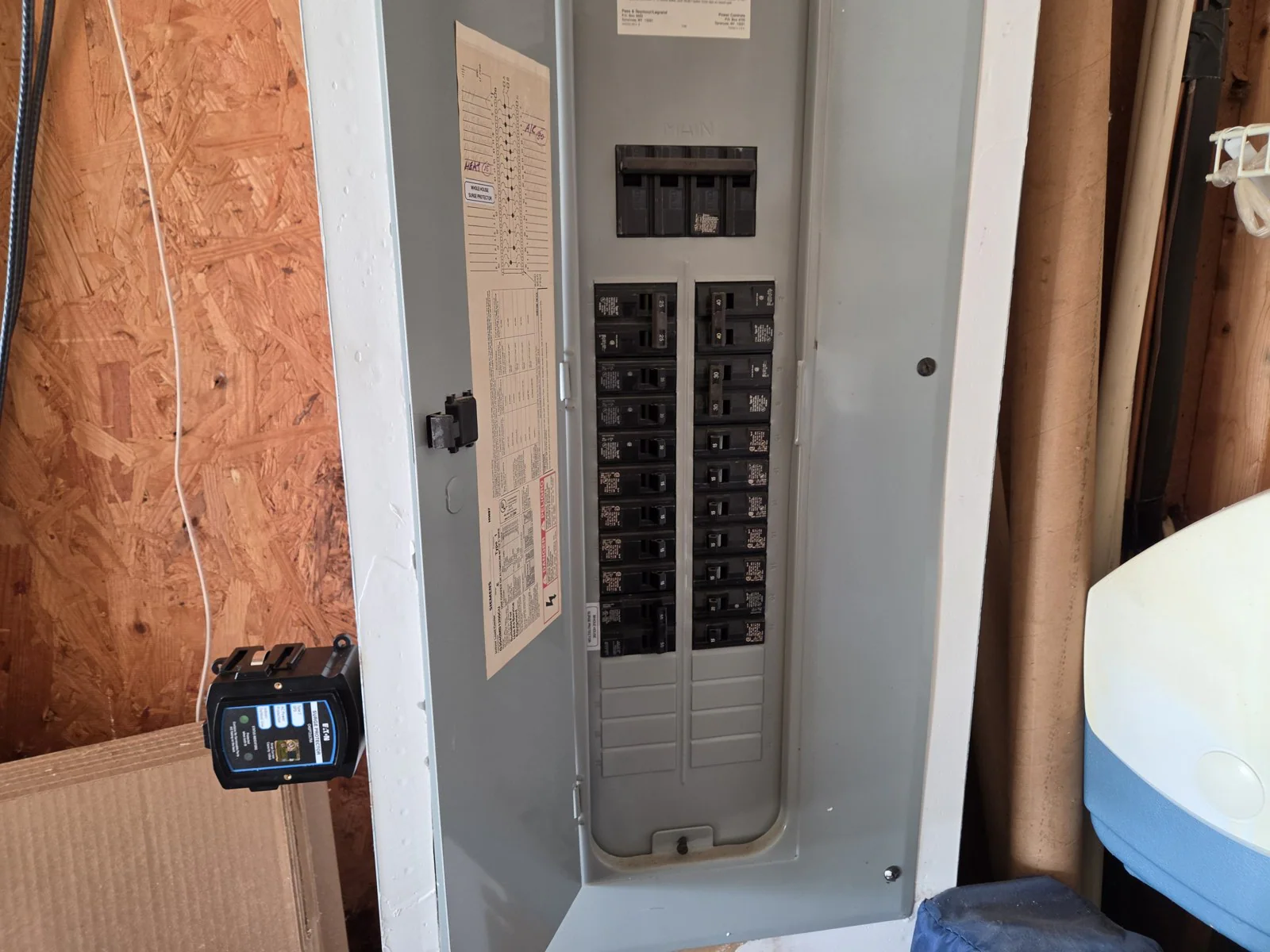 Open electrical panel with labeled breakers and a surge protector nearby, in Wakefield, Raleigh