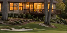 1980s home with a wooded yard near a golf course