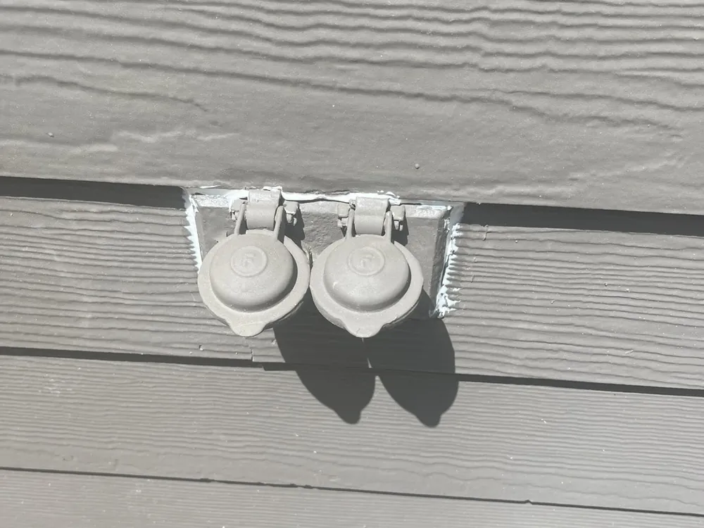 Two outdoor outlets with weatherproof covers on vinyl siding