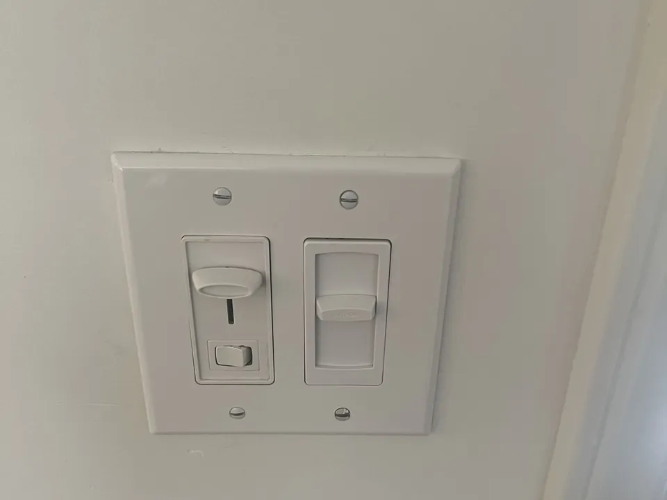 Dimmer and switch installed together in a two-gang wall plate