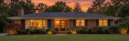 Mid-century ranch house with a low-pitched roof at dusk