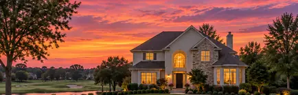 1990s two-story home beside a golf course fairway at dusk