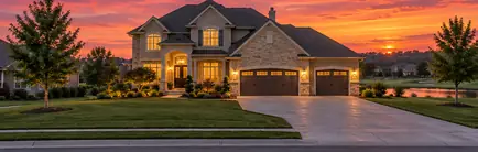 Large two-story home with a three-car garage on a golf community street at sunset