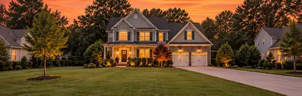 Two-story suburban home from the 2000s with a double garage at sunset