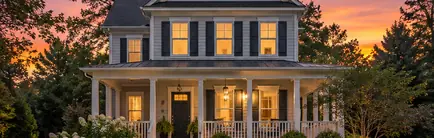 Older two-story frame house with a front porch in early evening light
