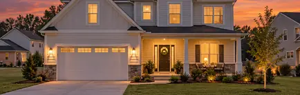 Brand-new two-story house with a two-car garage and a young lawn at dusk