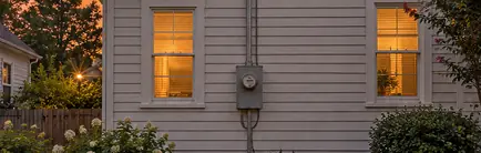 Electric meter and service mast on the side wall of an older house